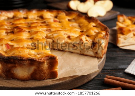 Traditional apple pie on black wooden table, closeup