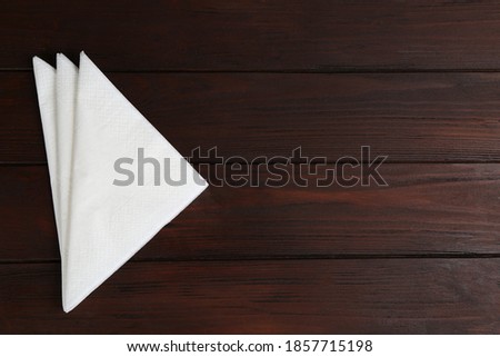 Clean napkins on wooden table, top view. Space for text Royalty-Free Stock Photo #1857715198