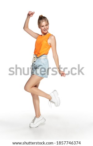 Happy young girl in casual wear isolated on white studio background.