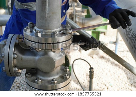 Worker hands screwing nuts on stainless steel pipe is part of new demineralized water process in oil & gas plant or chemical industrial. Royalty-Free Stock Photo #1857755521