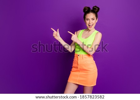 Photo of excited girl point index finger copyspace wear singlet isolated bright shine color background