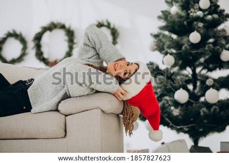 Young woman on sofa by the christmas tree