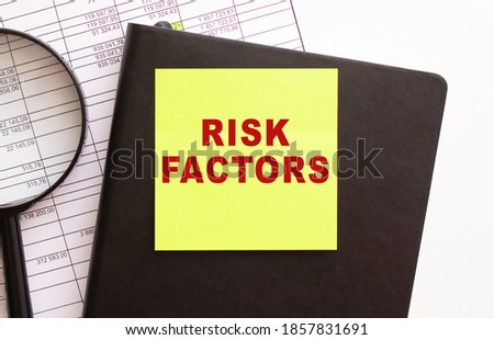 RISK FACTORS text on a sticker on your desktop. Diary and magnifier.