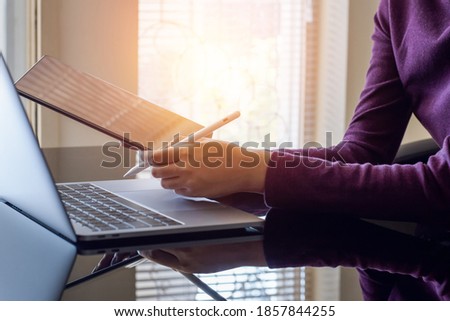 Business woman hand using electronic pen writing on digital tablet, work with laptop computer at office.