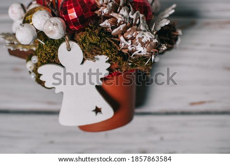 
Cute Christmas composition with a white angel, Christmas balls and white snowflakes. Modern floristry
