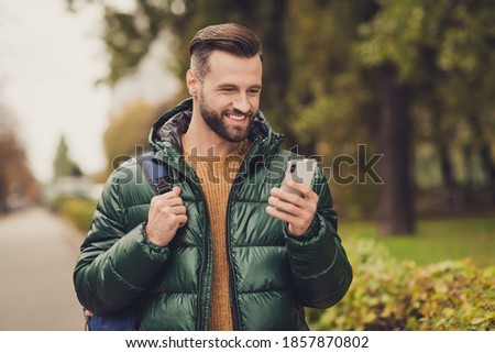 Photo of cheerful charming person write comment carry bag toothy smile wear fall style clothing walking outdoors