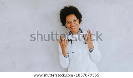 Female African American doctor wear white uniform and taking off face mask in the hospital