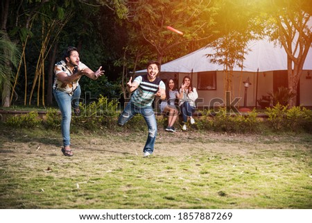 Group of Indian asian young people or friends in casual wear playing flying discs throwing while spending carefree time outdoors