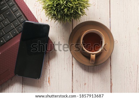  smart phone with empty screen, laptop on wooden background 