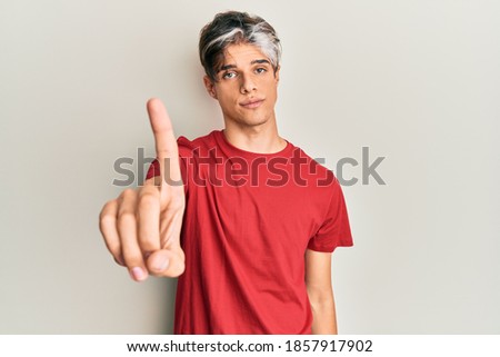 Young hispanic man wearing casual clothes pointing with finger up and angry expression, showing no gesture 