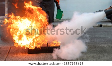 Man teaches or training how to use carbon dioxide  (CO2) fire extinguishers to extinguish fires from fuel. Royalty-Free Stock Photo #1857938698