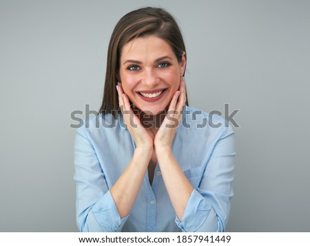 Happy smiling woman touching her face. Isolated portrait of young woman with big smile.
