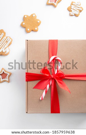 Christmas gift craft box with ribbon on white background with Christmas gingerbread