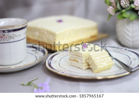 a picture of frozen cheesecakes that just came out of fridge on the table which is also placed on a wooden plate decorated with flowers and a fork to handle it in the afternoon on weekend as high tea.