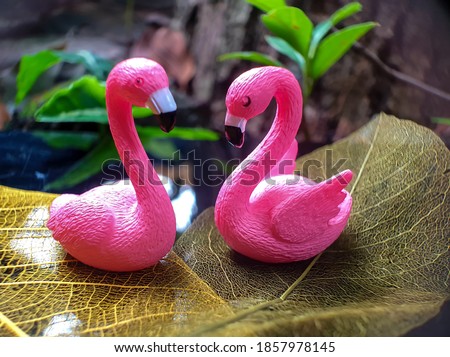 Miniature Couple of pink flamingos.  Stylized photo with colorful blurred background.love concept.selective focus.noised photo