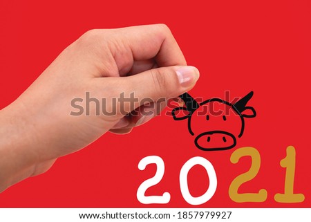 Year of the ox,background red woman hand holding ox picture,In the summer of 2021. New Year 2021, Japanese word of this image is "ox"