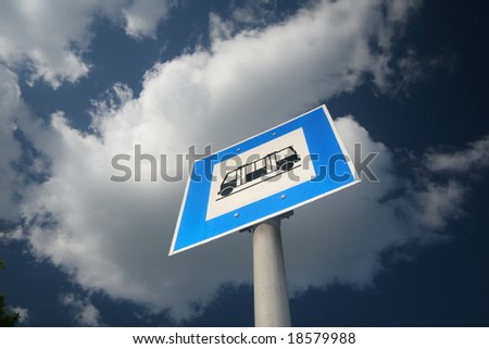 Bus stop sign against blue sky