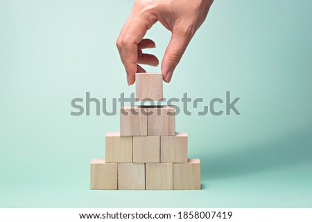 Hand putting and stacking blank wooden cubes with copy space for input wording and infographic icon.
