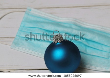 
blue christmas balls on a mouth nose covering, concept of christmas during pandemic
