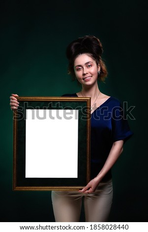 A young smiling caucasian woman holds a frame with a white space. Mock up. Copy space