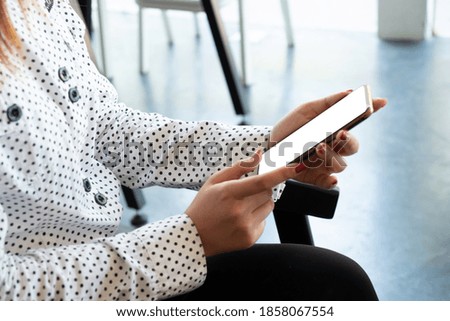 Woman holding smart phone with blurred background. For Graphic display montage.