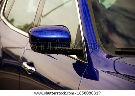 Rearview mirror. Part of a blue car