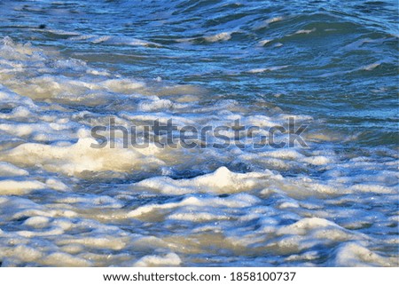 Small wave on the ocean shore, foam forms on the wave, close-up shot