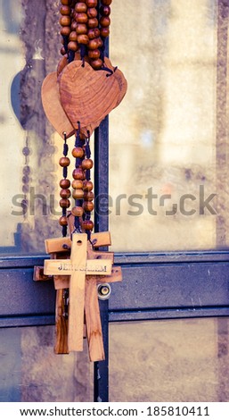 Wood rosary with the heart and the cross with inscription JERUSALEM. Closeup. Aged photo.