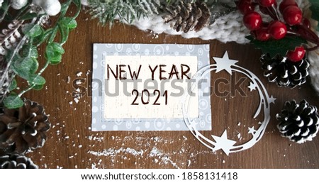 Beautiful text NEW YEAR 2021, written on a decorative plate against the background of New Year's decor. View from above. Christmas or festive concept.