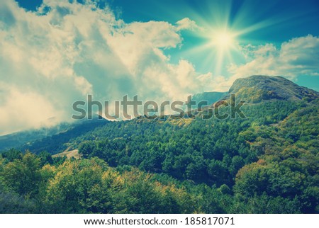 Vintage picture. Mountain landscape with clouds, lying on a hillside