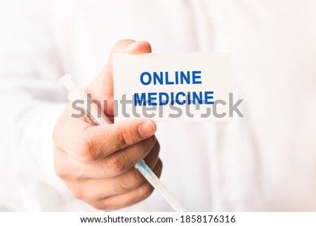 Word online medicine on a white background with a syringe in hand.