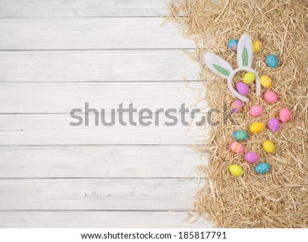 Cute and Colorful Easter Egg on Hay on Rustic White or Gray Board Background with room or space for copy, text.   Vertical
