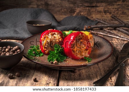 Stuffed peppers in a plate on a wooden brown background. Side view. Concept of culinary backgrounds. Royalty-Free Stock Photo #1858197433