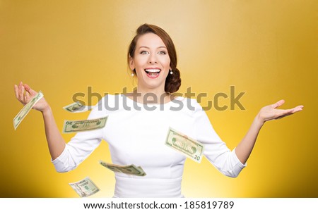 Closeup portrait super excited, laughing young woman who just won lots of money, trying to catch, throw dollar bills in air, isolated yellow background. Positive emotion, facial expression, feelings.