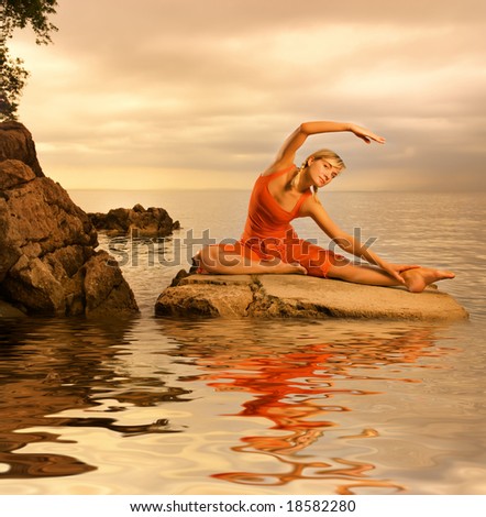 Beautiful young woman doing yoga exercise outdoors