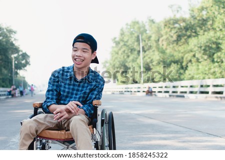 Asian special child on wheelchair is happily on mangrove forest background, Excited to travel on a holiday with family, Lifestyle in the education age of disabled children, Happy disabled kid concept.