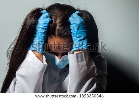 A stressed out medical worker. Bad news for the patient. Treatment was unsuccessful. Fatigue and frustration during the epidemic. Doctor in a protective mask against the coronavirus COVID-19