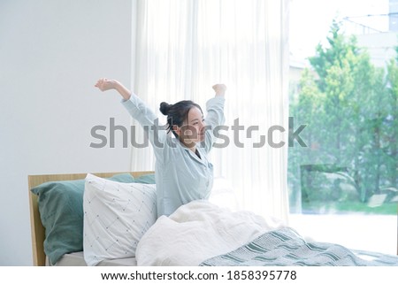 Asian woman waking up in the morning Royalty-Free Stock Photo #1858395778