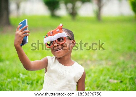 image of young african girl with smart phone- christmas concept
