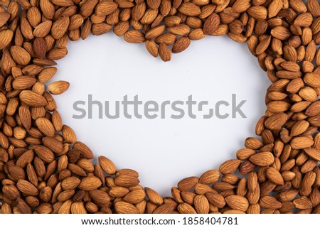 frame made of almonds in the shape of a heart. centered on a white background in the form of a heart.
