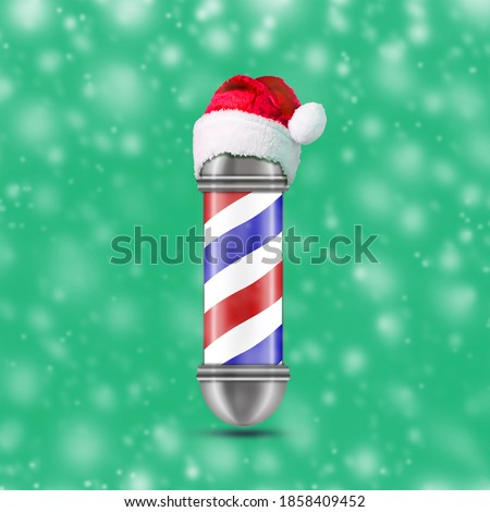 Barber pole in the hat of Santa Claus, on a green background. Snow effect. Beauty and fashion, Christmas background. Festive background.