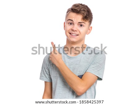 Cute teen boy pointing up, gesturing idea or doing number one gesture.