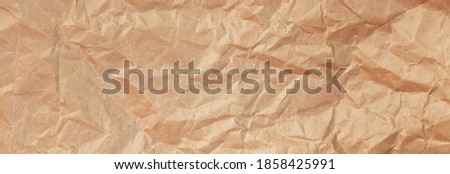 Background of crumpled craft paper for packaging. Banner format.