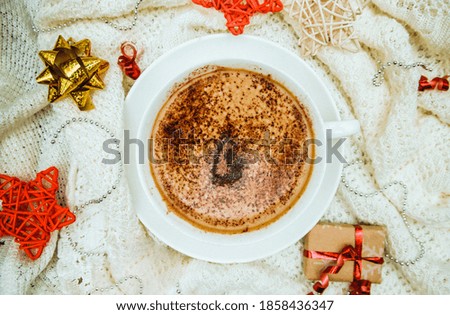 Coffee on the background of a warm knitted blanket with gifts and holiday bows.Hot winter drink. Cocoa and cappuccino.Festive, new year's background.