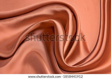 Shining red silk atlas satin fabric with folds, fabric waves. Red pink fabric background. Close up Royalty-Free Stock Photo #1858441912