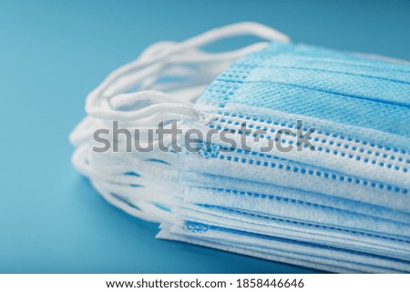 Stack of protective medical masks on a blue background, isolate.