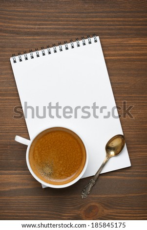 cup of coffee, spoon and note pad, concept photo, vertical