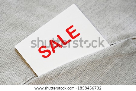 SALE word text on the short white note in the shirt pocket.