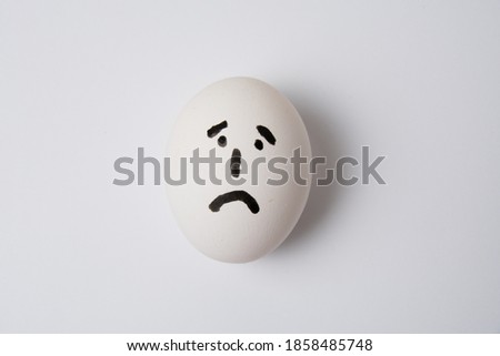 Egg with a sad and frustrated face, on a white background copy space