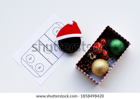 Santa hat and  hockey puck on white background. Hockey Santa. Top view. Christmas and New Year Holidays concept. Flat lay